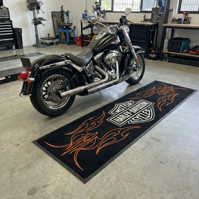 Harley Davidson motorcycle on a branded mat in a garage setting